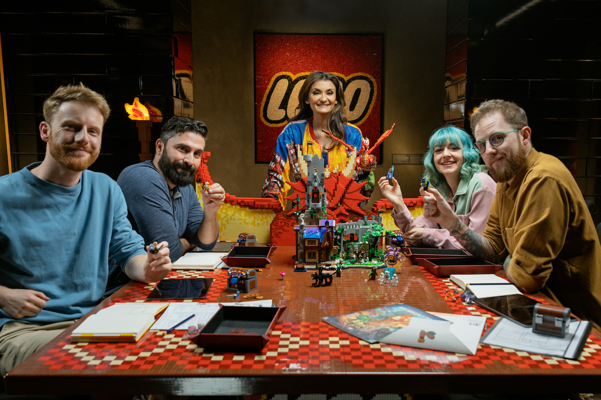 The cast of the LEGO-D&D actual play show seated at a LEGO brick table.